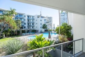 an apartment balcony with a swimming pool and buildings at Swell Resort Burleigh Heads in Gold Coast
