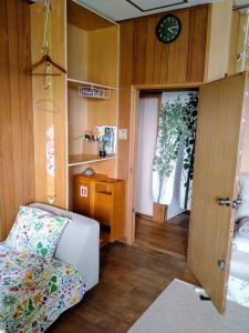 a small room with a bed and a clock on the wall at Minshuku Zabaru in Ishigaki Island