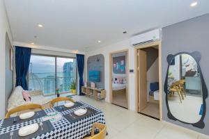 a room with a bed and a table and a mirror at The Sóng Infinity Pool Apartment Vung Tau Near Beach in Vung Tau