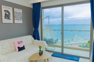 a living room with a couch and a large window at The Sóng Infinity Pool Apartment Vung Tau Near Beach in Vung Tau