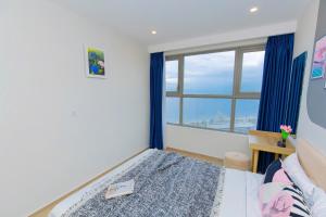 a bedroom with a bed and a large window at The Sóng Infinity Pool Apartment Vung Tau Near Beach in Vung Tau