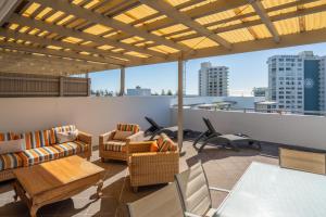 a living room with couches and chairs on a roof at Swell Resort Burleigh Heads in Gold Coast
