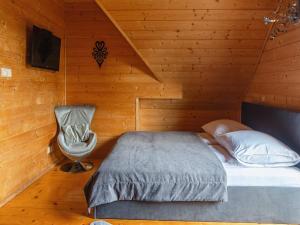 a bedroom with a bed and a chair at Luxury holiday villa, pool, sauna, jacuzzi in Nowy Targ