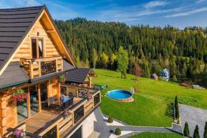 an aerial view of a log house with a swimming pool at Luxury holiday villa, pool, sauna, jacuzzi in Nowy Targ