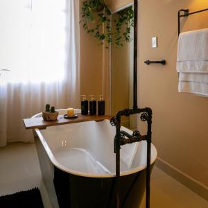 a bath tub in a bathroom with a shower at Habibi Hotel and SPA in San Miguel de Allende