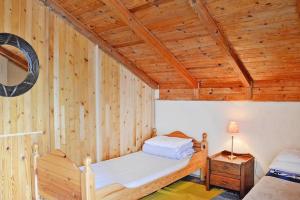 a bedroom with a wooden ceiling with two beds at Lakeside holiday villa, private garden in Wierzchowo