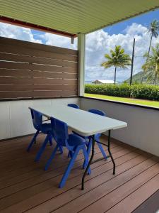 a table and chairs on a deck with a view of the ocean at Villa Blue Lagoon Tahaa in Tahaa