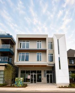 a large white building with windows on a street at Lovely Brand New Condo in Sidney