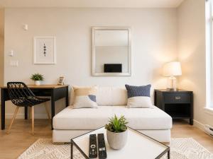 a living room with a white couch and a desk at Lovely Brand New Condo in Sidney