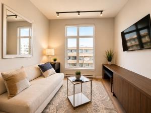 a living room with a couch and a tv at Lovely Brand New Condo in Sidney