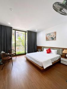 a large bedroom with a bed and a desk and window at Villa Flamingo B109 in Thanh Hóa