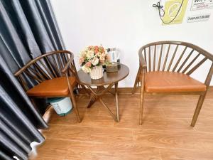 two chairs and a table with flowers on it at Villa Flamingo B109 in Thanh Hóa