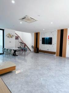 a room with a table and a tv on a wall at Villa Flamingo B109 in Thanh Hóa