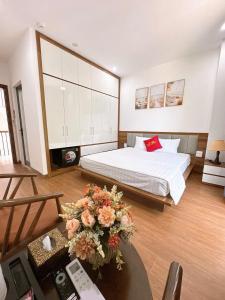 a bedroom with a bed and a table with flowers at Villa Flamingo B109 in Thanh Hóa