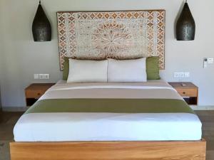 a bedroom with a large bed with two tables at Emocean Beach Boutique Dive Resort in Amed +35 photos