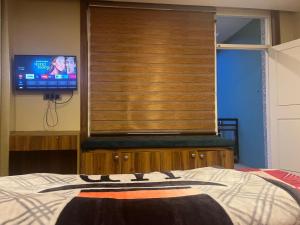 a bedroom with a bed and a tv in a window at Monkeys Junction in Manāli