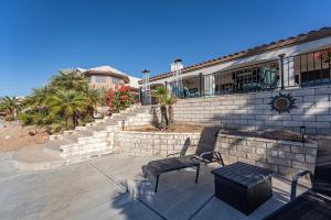 a patio with two chairs and a bench in front of a building at Lake House in Fort Mohave