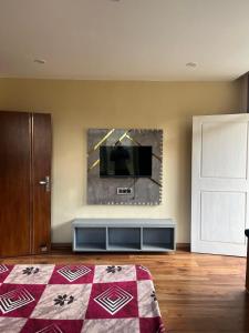a bedroom with a flat screen tv on a wall at Monkeys Junction in Manāli