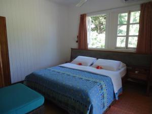 sypialnia z łóżkiem z 2 poduszkami i oknem w obiekcie Chez Michellin Pensions Residence w mieście La Digue
