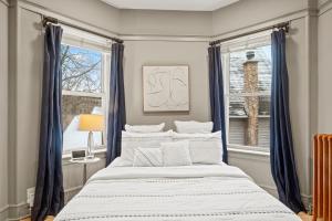 a bedroom with a large bed with blue curtains at Elegant and Chic 2Bed 2Bath steps from the lake! in Chicago