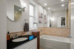 a bathroom with a sink and a tub and a mirror at Elegant and Chic 2Bed 2Bath steps from the lake! in Chicago +20 photos