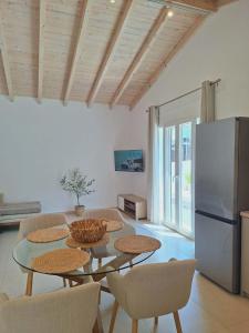 a kitchen with a table with chairs and a refrigerator at Villa Eleni Apartment no3 in Agios Gordios
