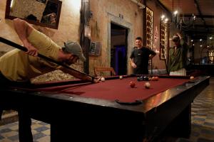 a man is playing pool on a pool table at Che Valladolid Hostel & Bar in Valladolid