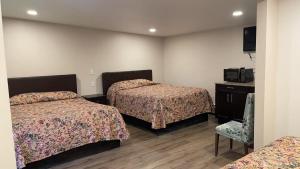 a hotel room with two beds and a chair at Kluane Park Inn in Haines Junction