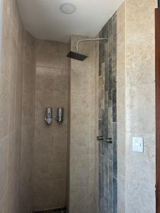 a bathroom with a shower with a glass door at Hotel La Bikina in Tequila