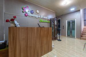 a lobby of a clinic with a wooden reception desk at Hotel Dahlia By ARBA in Jakarta