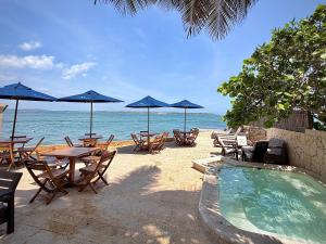 a group of tables and chairs with umbrellas on the beach at Hotel Caribbean Cartagena in Cartagena de Indias