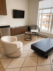 a living room with two chairs and a table and a tv at Lovely Brand New Suite in Sidney