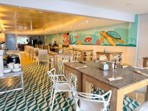 a restaurant with tables and chairs and a mural at Hotel Caribbean Cartagena in Cartagena de Indias