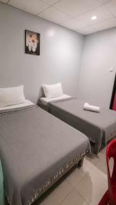 a room with two beds and a red chair at ML SUITES CEBU in Cebu City