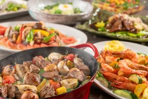 a table with plates of food and a pan of food at Tazawako Lake Resort & Onsen in Senboku