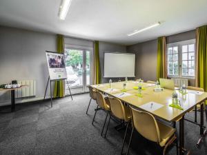a meeting room with a large table and a screen at ibis Styles Saint Brieuc Plerin in Plérin