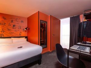 a bedroom with a bed and a desk with a laptop at Ibis Styles Paris Gare de l'Est Magenta in Paris +104 photos