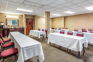 a conference room with white tables and red chairs at Wingate by Wyndham Conway AR in Conway