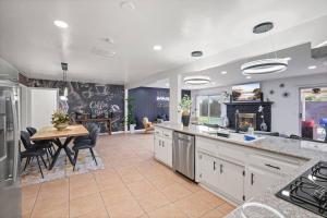 a kitchen with a table and a dining room at Heated Pool - Jacuzzi - Firepit - Game Room in Hemet