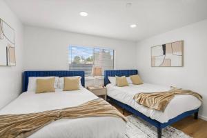 two beds sitting next to each other in a bedroom at Heated Pool - Jacuzzi - Firepit - Game Room in Hemet +65 photos