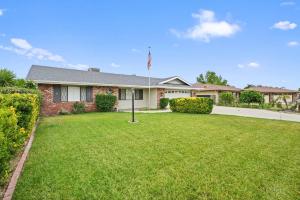 a house with a flag in a yard at Heated Pool - Jacuzzi - Firepit - Game Room in Hemet