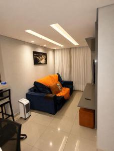a living room with a blue couch with an orange blanket at apartamento Seminate 2 in Franca