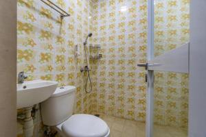 a bathroom with a toilet and a sink at Hotel Dahlia By ARBA in Jakarta