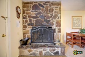 a fireplace in a room with a stone wall at Aspen East Unit #101 in Basye