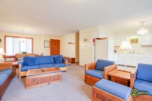 a living room with blue couches and a kitchen at Villa #114 in Basye