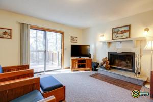a living room with a fireplace and a tv at Villa #114 in Basye