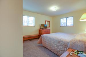 a bedroom with a bed and a tv and two windows at Villa #119 in Basye
