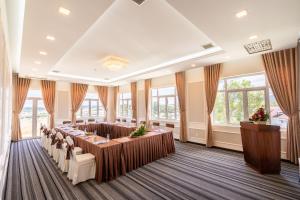 a large room with tables and chairs and windows at Navy Hotel Da Lat in Da Thien +56 photos