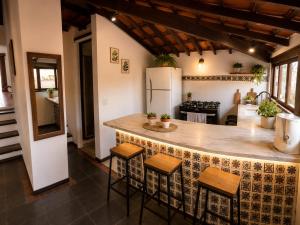 a kitchen with a large island with stools at Pousada Mojomar Buzios in Búzios