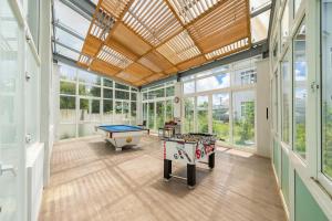 a large room with a pool table and windows at Navy Hotel Da Lat in Da Thien